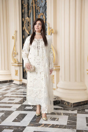Woman in a white lace dress standing in an elegant interior setting